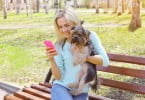 rapariga com smartphone e cão Veterinária Atual